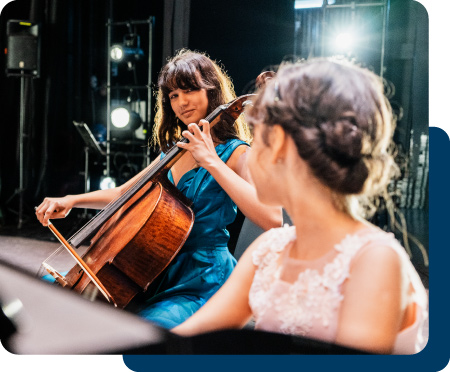 A violinist and pianist on stage together at a concert.
