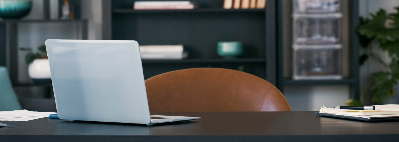 Image of a office desk with a laptop and notebook.