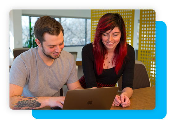 two DonorPerfect employees working on a laptop