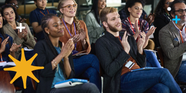 A group of conference attendees clapping.