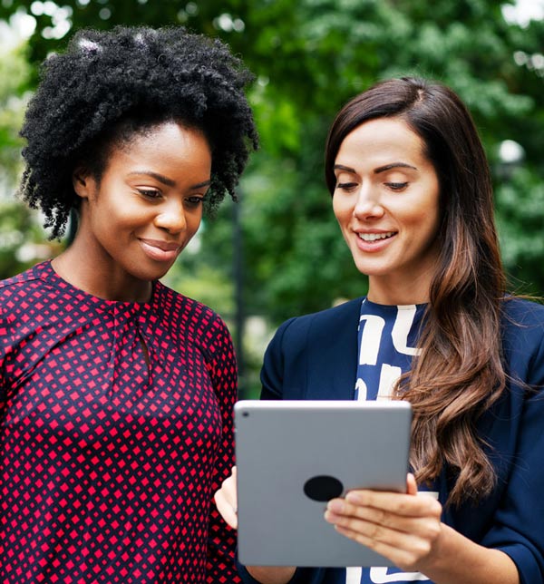 two women using ipad to enter their information