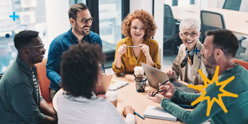 A group of employees conversing in a meeting room.