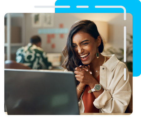 Person happily looking at her computer in an office setting. 