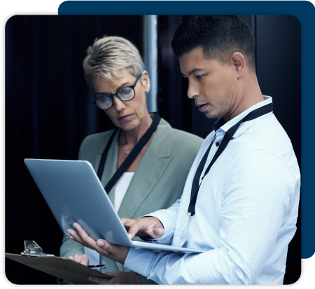 A man is holding a computer while he and his colleague look at the screen.