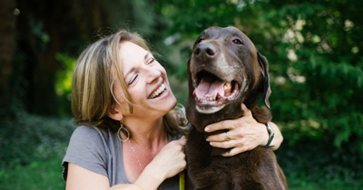 Woman holding dog smiling