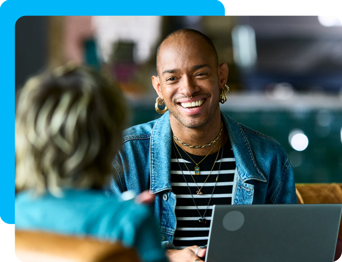 Nonprofit worker using a computer in conversation with a potential donor.