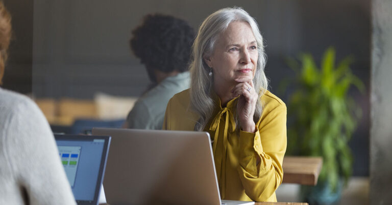 A woman thinking at her laptop.