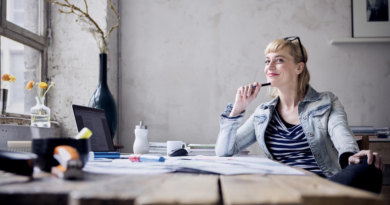 A woman thinking at her desk.
