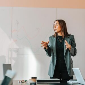 Female business entrepreneur explaining strategies to colleagues in board room at office