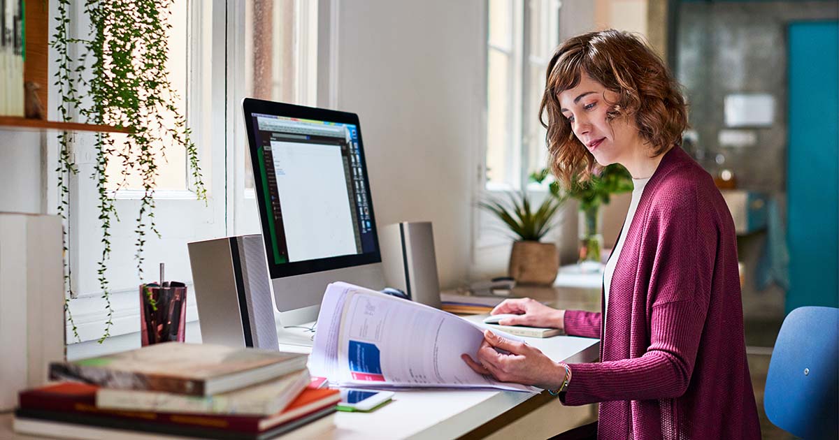 A woman working with receipts at her computer.