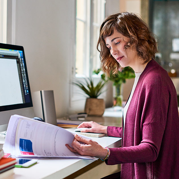 A woman working with receipts at her computer.