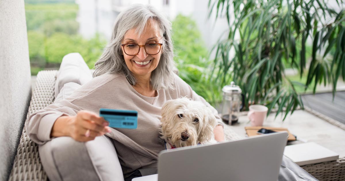Donor with dog on her computer updating her credit card information - header image