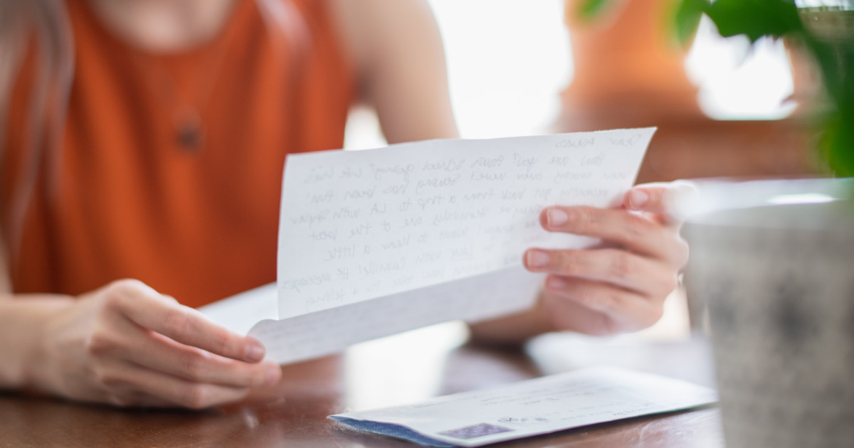 Detail view of young woman reading letter