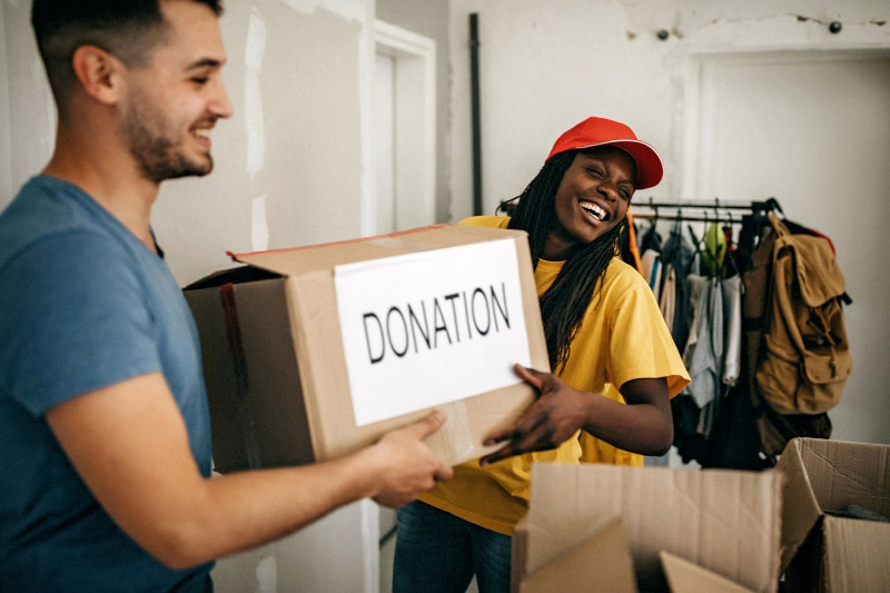 two people holding a donation box