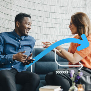 Businessman and woman using mobile phones while sitting on couch during conference