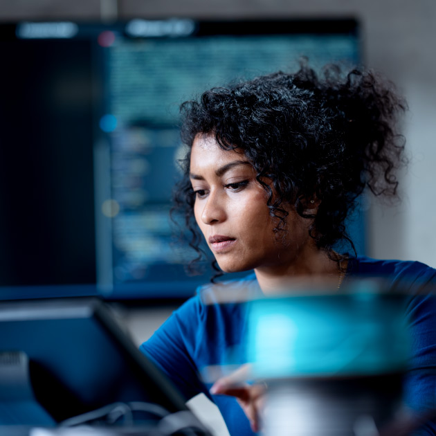 Improve Automate Workflows and Streamline Software Testing with Machine Learning in Software Development. An Asian female software developer coding or debugging code on a computer at her desk in the tech office.