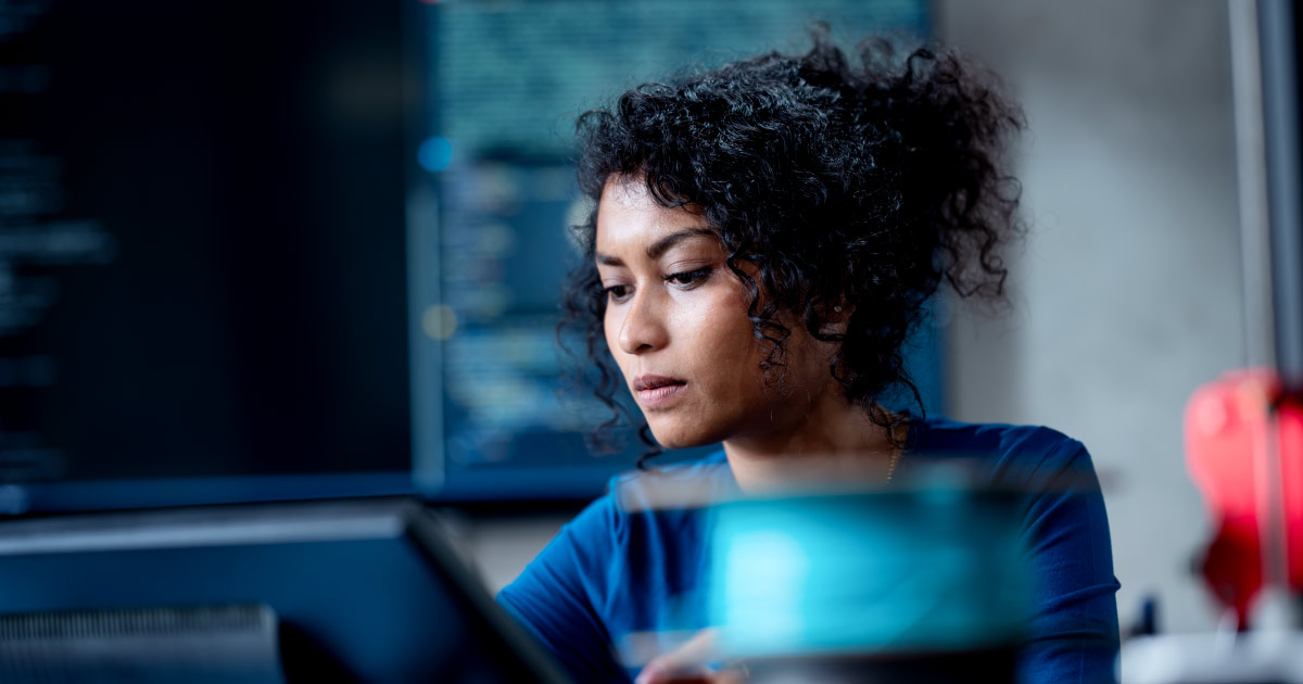 Improve Automate Workflows and Streamline Software Testing with Machine Learning in Software Development. An Asian female software developer coding or debugging code on a computer at her desk in the tech office.