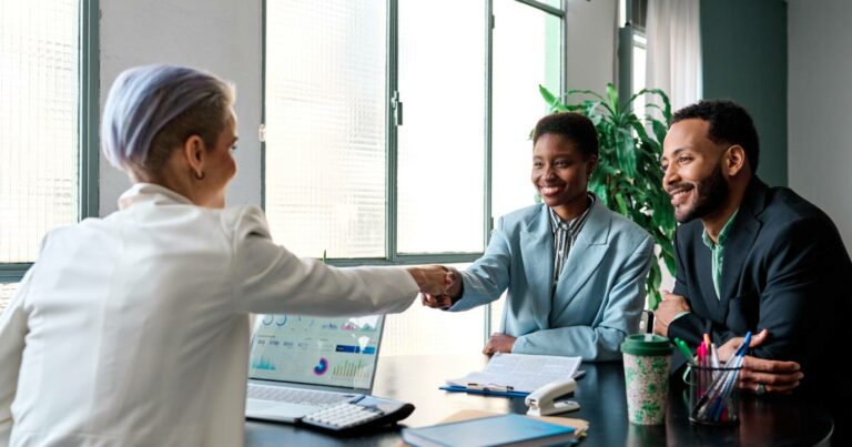 Businesswoman shaking hands to close a deal with clients in the office - multiethnic group