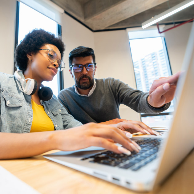 Image of two coworkers working on a computer