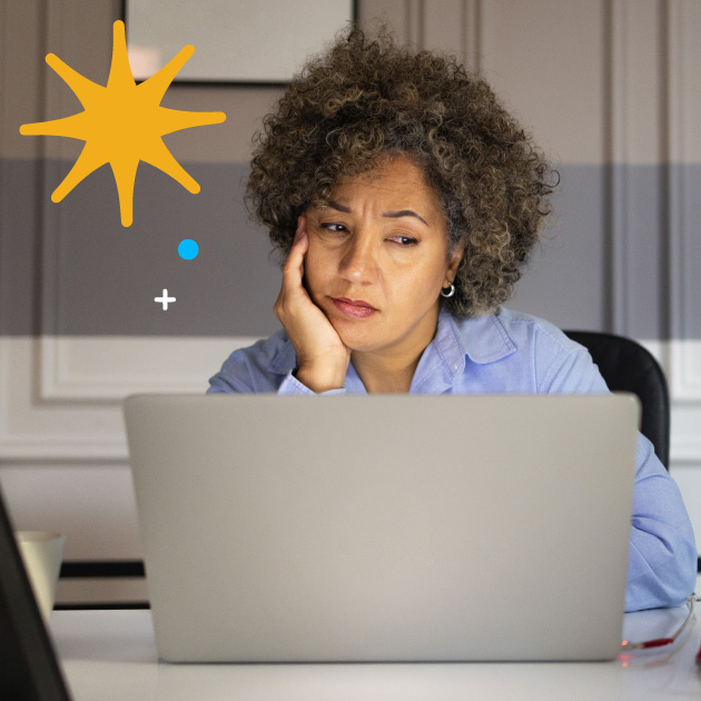 Image of a woman looking listless at a computer.