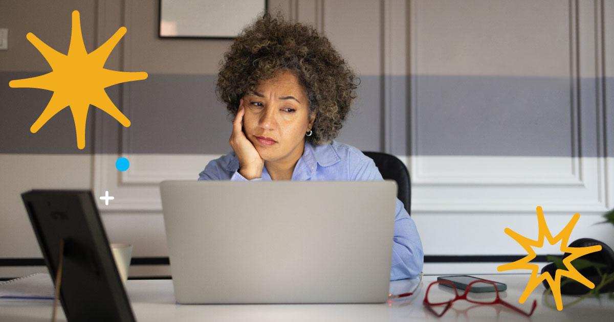 Image of a woman looking listless at a computer.