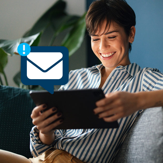 Woman happily reading an email on her tablet.