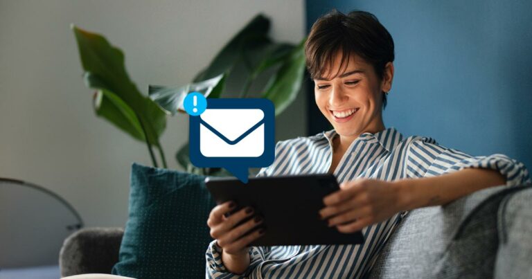 Woman happily reading an email on her tablet.