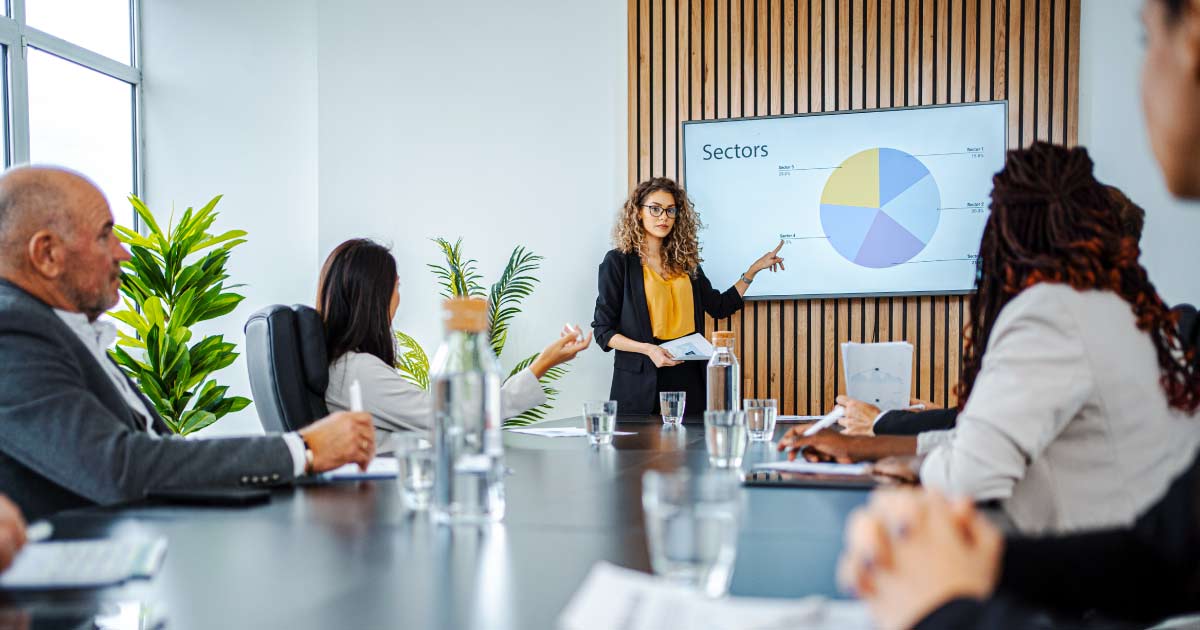 Businesswoman leading business meeting using statistics chart on presentation TV