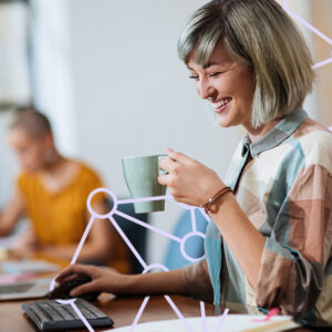 Woman holding a cup of coffee while working at an office.