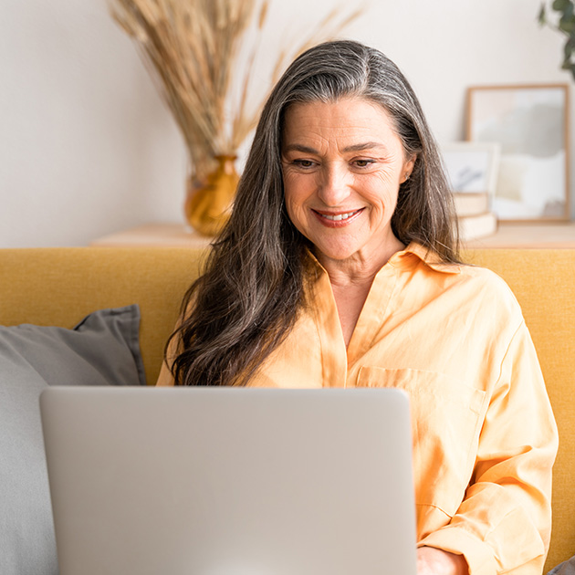 A woman on the laptop on a couch.