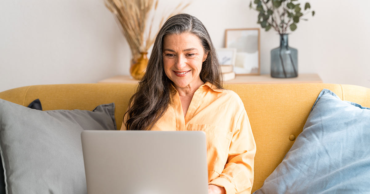 A woman on the laptop on a couch.