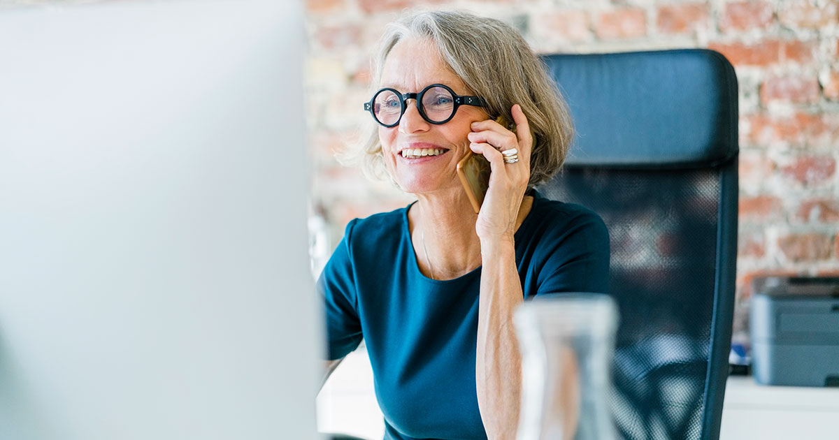 A woman on the phone at her computer.