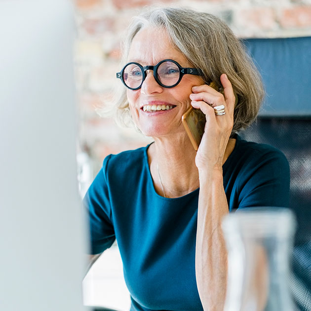 A woman on the phone at her computer.