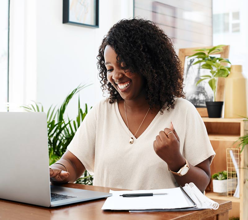 Shot of a young businesswoman cheering while working in an office